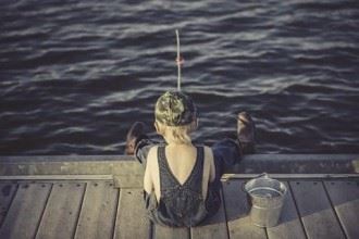 Boy sitting down and fishing